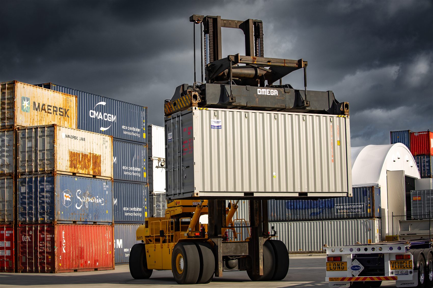 A container handler stacking a container in the yard