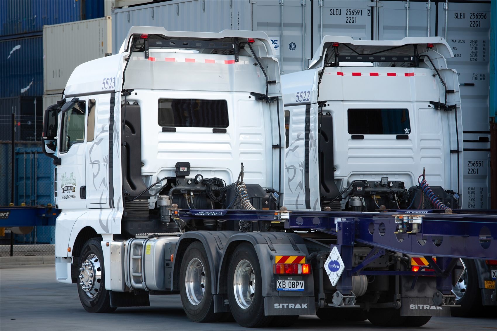 Two Windle's trucks on empty container chassis, ready to collect